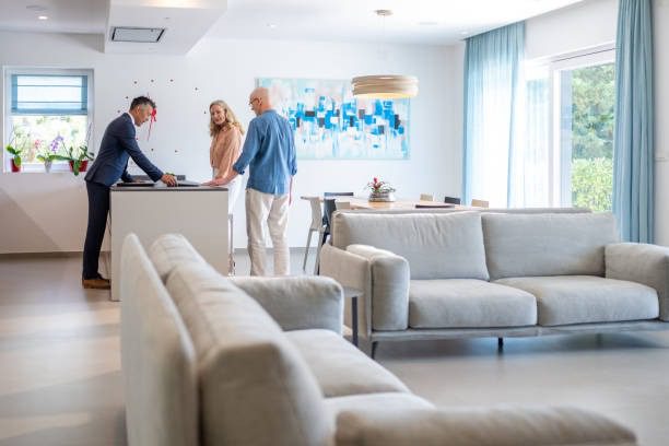 Clients reviewing the rental agreement with agent inside spacious contemporary apartment.